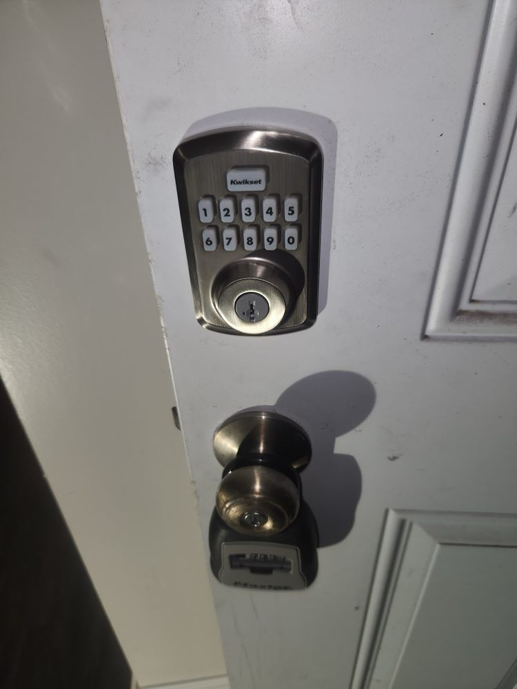 Keypad deadbolt and door knob installed on a gray door